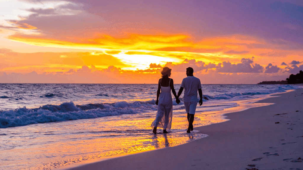 Couple walking on a golden Goa beach at sunset – popular Goa honeymoon packages 2026 - Most Romantic Things to Do in Goa for Couples